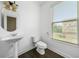 Bright powder room with pedestal sink, toilet, and window with blinds at 262 Bell Grove Ln, Suwanee, GA 30024
