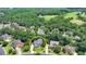 Aerial view of a brick home with a beautifully landscaped front yard situated in a lush, green neighborhood at 5357 Harbury Cv, Suwanee, GA 30024