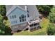 An aerial view of the home's back exterior showing a large deck and lush green lawn at 5357 Harbury Cv, Suwanee, GA 30024