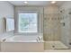 A bright bathroom with a separate tub and shower combo at 5357 Harbury Cv, Suwanee, GA 30024
