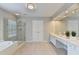 Spacious bathroom features a walk-in shower, soaking tub, double sinks, and a large mirror at 5357 Harbury Cv, Suwanee, GA 30024
