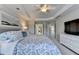 View of the main bedroom featuring a tray ceiling, ceiling fan, and ensuite bathroom access at 5357 Harbury Cv, Suwanee, GA 30024