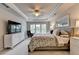 This comfortable main bedroom features large windows, a ceiling fan, and neutral colors for a relaxing space at 5357 Harbury Cv, Suwanee, GA 30024