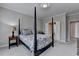 Tranquil bedroom with four-poster bed, soft carpet, and adjacent hallway at 5357 Harbury Cv, Suwanee, GA 30024
