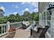 Outdoor deck with wicker furniture and a view of surrounding trees at 5357 Harbury Cv, Suwanee, GA 30024