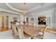 Elegant dining room boasting a chandelier, crown molding, and an adjacent office space with French doors at 5357 Harbury Cv, Suwanee, GA 30024