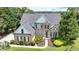 Gorgeous two-story brick home featuring a meticulously maintained lawn and beautiful landscaping details at 5357 Harbury Cv, Suwanee, GA 30024