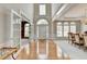 Elegant foyer showcasing hardwood floors, high ceilings, arched windows, and an open view into the dining room at 5357 Harbury Cv, Suwanee, GA 30024