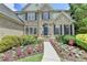 Charming home featuring blooming flowers, lush bushes, and a welcoming walkway leading to the front door at 5357 Harbury Cv, Suwanee, GA 30024
