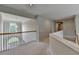 Bright hallway featuring natural light, railing, and neutral color palette for a calming and welcoming space at 5357 Harbury Cv, Suwanee, GA 30024