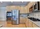 Well-equipped kitchen features stainless steel appliances, wooden cabinets, gas stovetop, and hardwood floors at 5357 Harbury Cv, Suwanee, GA 30024