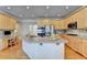 Bright kitchen with light wood cabinets, center island, and stainless steel appliances at 5357 Harbury Cv, Suwanee, GA 30024