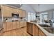 Open kitchen with light wood cabinets, stainless appliances, and breakfast nook at 5357 Harbury Cv, Suwanee, GA 30024