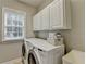 Well-equipped laundry room with ample cabinet space and modern washer and dryer at 5357 Harbury Cv, Suwanee, GA 30024