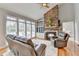 Comfortable living room with stone fireplace, hardwood floors, and large windows at 5357 Harbury Cv, Suwanee, GA 30024