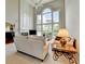 Comfortable living room featuring high ceilings, large windows, and neutral decor at 5357 Harbury Cv, Suwanee, GA 30024