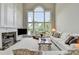 Bright living room with soaring windows, fireplace and white furniture at 5357 Harbury Cv, Suwanee, GA 30024