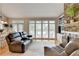 Bright living room with stone fireplace, plush seating, and seamless dining area access at 5357 Harbury Cv, Suwanee, GA 30024