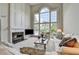 Bright living room with soaring windows, fireplace and white furniture at 5357 Harbury Cv, Suwanee, GA 30024