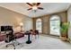 Spacious office with neutral walls, chair rail trim, 2 windows, tan carpet, and ceiling fan at 5357 Harbury Cv, Suwanee, GA 30024