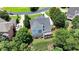 Aerial view of a house with a spacious back deck and a lush green backyard surrounded by trees at 5357 Harbury Cv, Suwanee, GA 30024