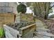 Wooden stairs leading up an embankment with flower planters and landscaping at 5357 Harbury Cv, Suwanee, GA 30024