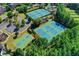 Aerial view of the community tennis and basketball courts surrounded by mature trees at 5357 Harbury Cv, Suwanee, GA 30024