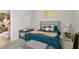 Comfortable bedroom with blue bedding, grey upholstered headboard, and a view into the ensuite bathroom at 10 Nesbit Reserve Ct, Atlanta, GA 30350