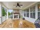 Covered outdoor patio with a brick fireplace, ceiling fan, and wooden flooring for relaxation at 10 Nesbit Reserve Ct, Atlanta, GA 30350