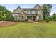 Beautiful two-story home featuring a stone facade, manicured lawn, and inviting front porch at 10 Nesbit Reserve Ct, Atlanta, GA 30350