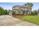 Elegant two-story home with stone and siding exterior, concrete driveway, and manicured lawn at 10 Nesbit Reserve Ct, Atlanta, GA 30350
