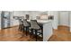 Bright kitchen with white cabinets, stainless refrigerator, granite counters, and an island with barstool seating at 10 Nesbit Reserve Ct, Atlanta, GA 30350