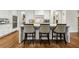 Bright kitchen with white cabinets, stainless appliances, granite counters, and an island with barstool seating at 10 Nesbit Reserve Ct, Atlanta, GA 30350