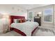 Comfortable main bedroom with a red tufted headboard, decorative pillows, and bright windows at 10 Nesbit Reserve Ct, Atlanta, GA 30350