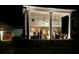 Grand estate exterior featuring a columned facade and guests enjoying the evening on the veranda at 1242 Star Ne Dr, Brookhaven, GA 30319