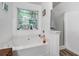 This bright bathroom features a large tub, shower, and an outside view at 248 Springbottom Dr, Lawrenceville, GA 30046
