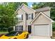 Charming two-story home showcasing a tan exterior, black shutters and a yellow luxury car parked in the driveway at 248 Springbottom Dr, Lawrenceville, GA 30046