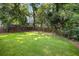 Large backyard featuring green lawn, wooden fence, and mature trees offering privacy at 555 Orme Ne Cir, Atlanta, GA 30306