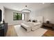 Bright bedroom features a modern light fixture, large window, wood floors, and neutral decor at 555 Orme Ne Cir, Atlanta, GA 30306