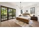Bedroom featuring dark frame windows, wood floors, with a modern chandelier at 555 Orme Ne Cir, Atlanta, GA 30306