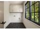 Laundry room with tiled floor, white cabinets, and window with outdoor view at 555 Orme Ne Cir, Atlanta, GA 30306