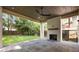Outdoor living space featuring a stone patio, wooden ceiling, and fireplace with lush backyard views at 555 Orme Ne Cir, Atlanta, GA 30306