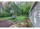 The side of this home offers a stone path, established planting beds, and mature trees at 600 River Bend Sw Cir, Smyrna, GA 30082