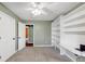 Carpeted bedroom featuring a ceiling fan and custom built-in shelving with a built-in desk space at 600 River Bend Sw Cir, Smyrna, GA 30082