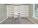 Carpeted bedroom featuring custom built in shelving and desk near the window for home office use at 600 River Bend Sw Cir, Smyrna, GA 30082