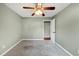 Carpeted bedroom featuring a ceiling fan, window, and a door leading to another room at 600 River Bend Sw Cir, Smyrna, GA 30082