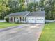 Single-story home featuring an attached two-car garage, white picket fence, and an expansive front lawn at 600 River Bend Sw Cir, Smyrna, GA 30082