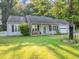 Charming single-story home with a well-manicured lawn and an inviting front porch with wicker seating at 600 River Bend Sw Cir, Smyrna, GA 30082