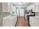 Well-lit kitchen features white cabinets, stainless steel appliances, and hardwood floors at 600 River Bend Sw Cir, Smyrna, GA 30082