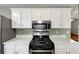 Close-up of the kitchen range with white countertops and cabinets at 600 River Bend Sw Cir, Smyrna, GA 30082